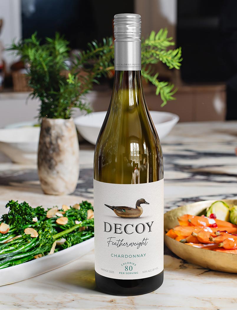 Decoy Featherweight California Chardonnay with vegetable dishes on a countertop